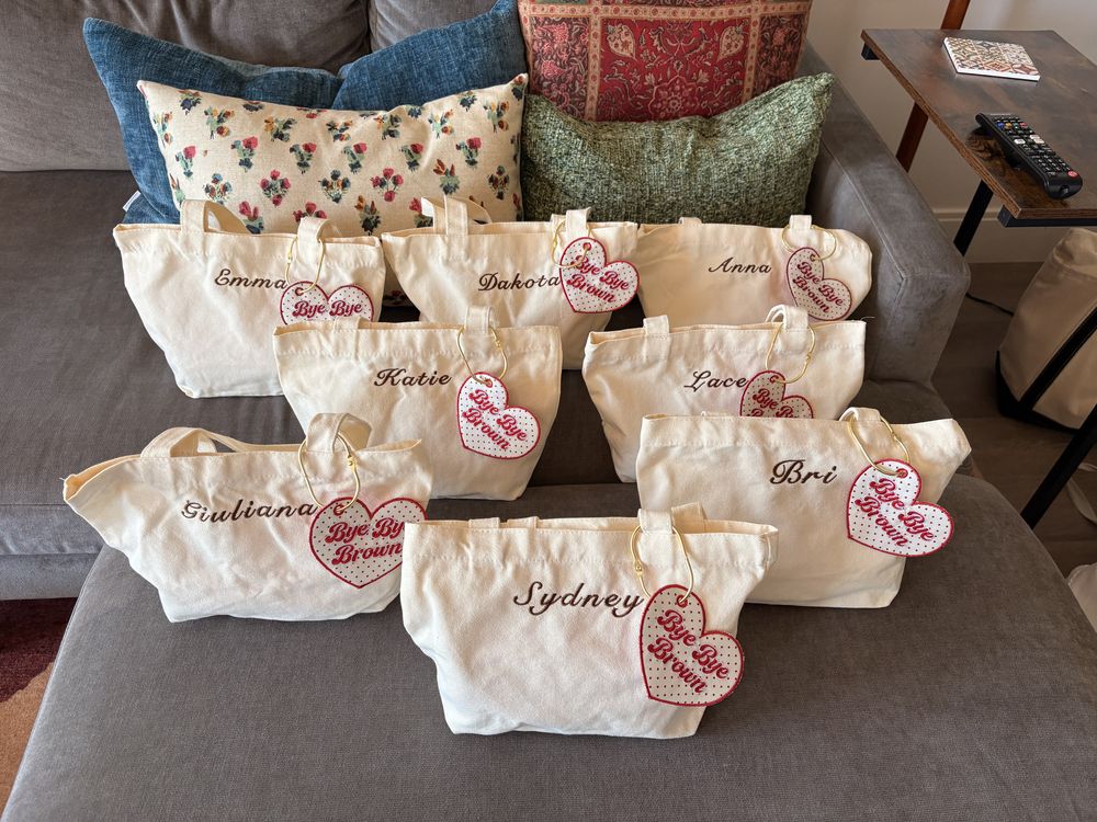 Canvas totes with guest names and a matching heart charm keyring, welcome bags
